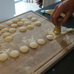 Ręcznie robione ravioli z pysznym farszem do ravioli, przygotowywane na drewnianej desce.