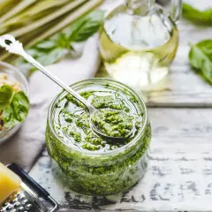 Pesto bazyliowe w słoiku, obok orzeszki piniowe, ser parmezan i oliwa. Idealne do makaronu, na grzanki i do sałatek.