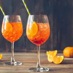 Dwa orzeźwiające drinki Aperol Spritz z pomarańczą i lodem, idealne na letnie popołudnie.