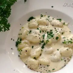 Puszyste gnocchi z gorgonzolą w kremowym sosie, posypane świeżą natką pietruszki. Idealne danie dla miłośników włoskich smaków.