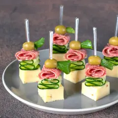 Koreczki przystawka: kostki sera, plasterki ogórka, salami i oliwka na wykałaczce.