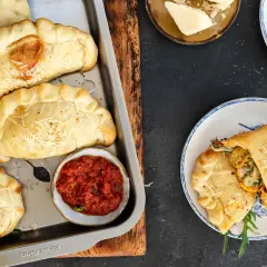 Mini calzone przepis: złociste, pieczone pierożki z serem i ziołami, podane z sosem pomidorowym. Idealne na przekąskę.