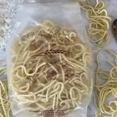 Pici, tradycyjny toskański makaron, w opakowaniu Bargagli. Idealny do prostego przepisu na pici. Obok mąka i drewniana łyżka.