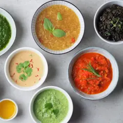 Różnorodne sosy do grilla: zielony, pomarańczowy, czerwony, czarny, biały i żółty, tworzą barwną paletę smaków.