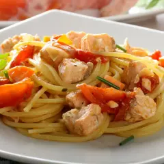 Pyszny makaron z wędzoną rybą, pomidorami i świeżą bazylią. Idealny na szybki obiad.