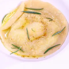 Ravioli z płynnym żółtkiem, ozdobione rozmarynem i przyprawami, danie godne MasterChefa.