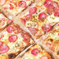 Kawałki pysznej, gorącej pizza włoska z kiełbasą i serem, posypane ziołami. Idealna na spotkanie z przyjaciółmi.