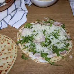 Przygotowanie pysznej piadiny romagnola z rukolą, szynką i parmezanem.