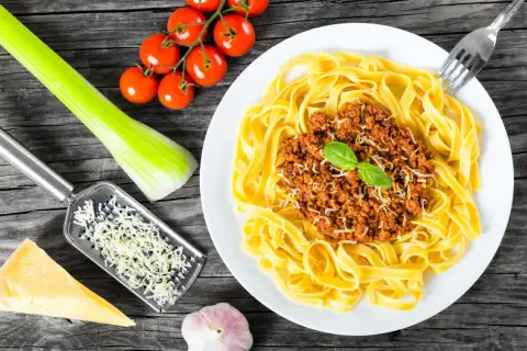 Pyszne tagliatelle z ragu bolognese, świeże pomidorki, czosnek i parmezan. Idealny przepis na ragout.