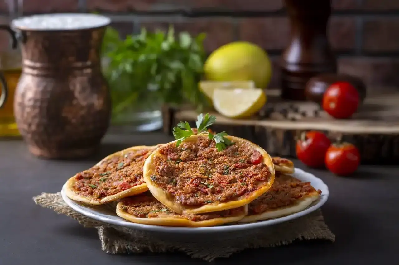 Lahmacun co to? Pyszne, cienkie placki z mięsem mielonym, pomidorami i ziołami, przypominające turecką pizzę.