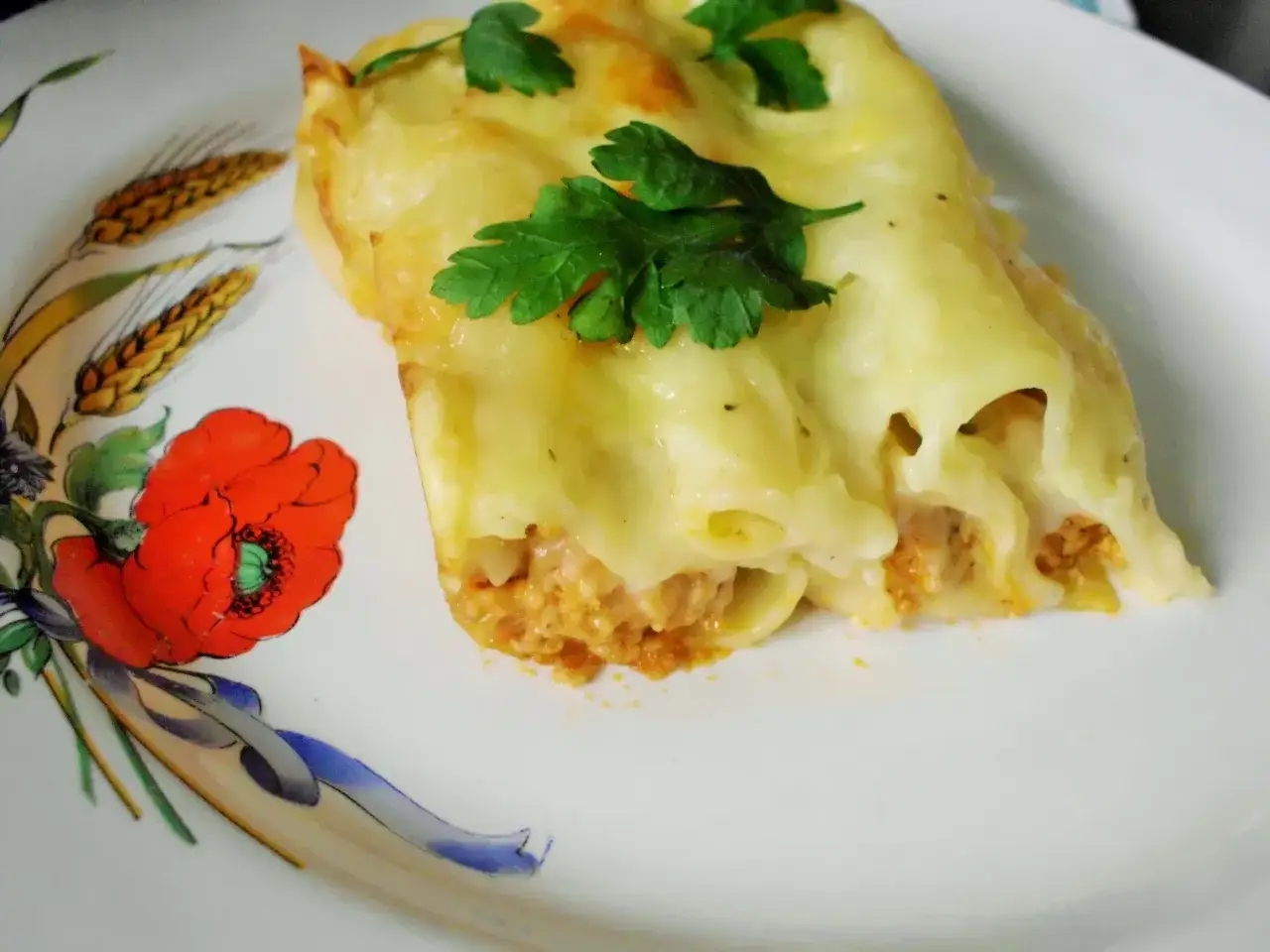 Pyszne cannelloni zapieczone pod beszamelem i serem, podane na talerzu z makami. Idealny sos do cannelloni.