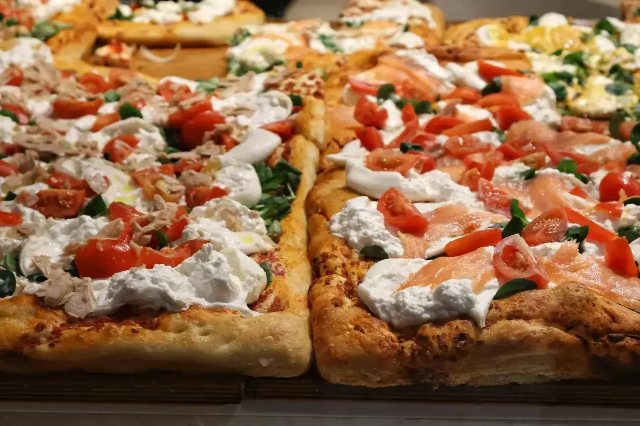 Pyszna pizza z mozzarellą, pomidorkami i łososiem. Idealna na szybki lunch.