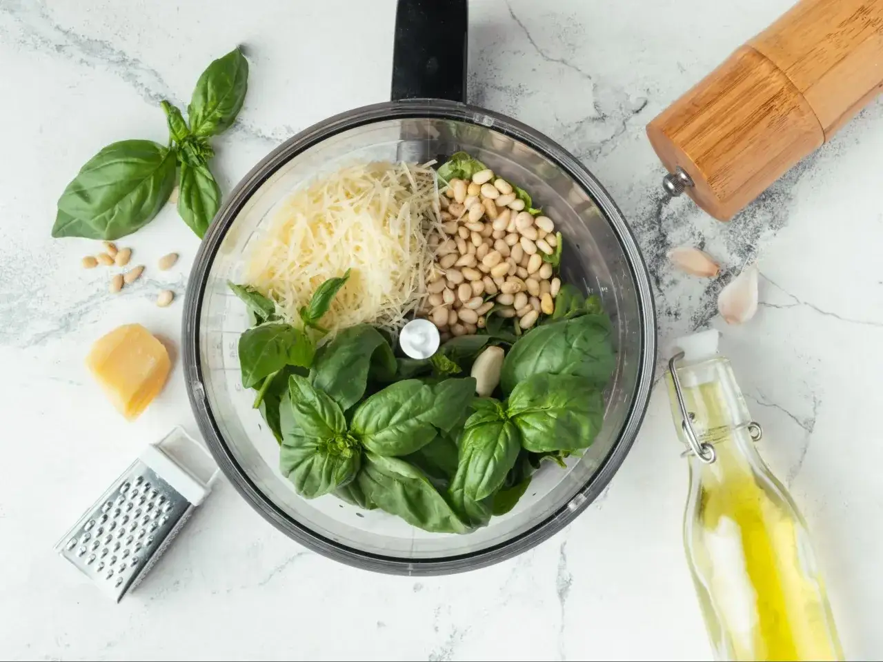 Składniki do przygotowania różnych rodzajów pesto: bazylia, orzeszki piniowe, parmezan, czosnek i oliwa.