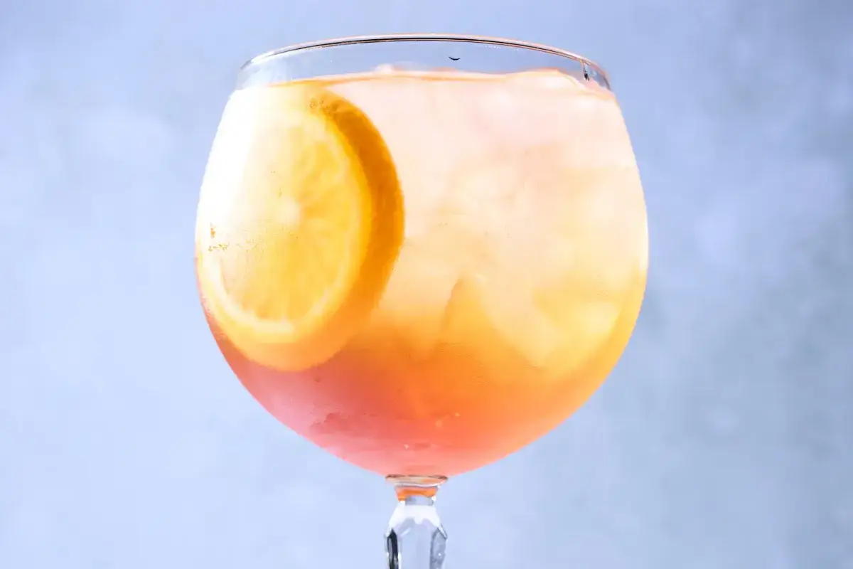 Orzeźwiający Aperol Spritz z plasterkiem pomarańczy i lodem. Idealny aperitif, gdy szukasz prostego aperol przepis.