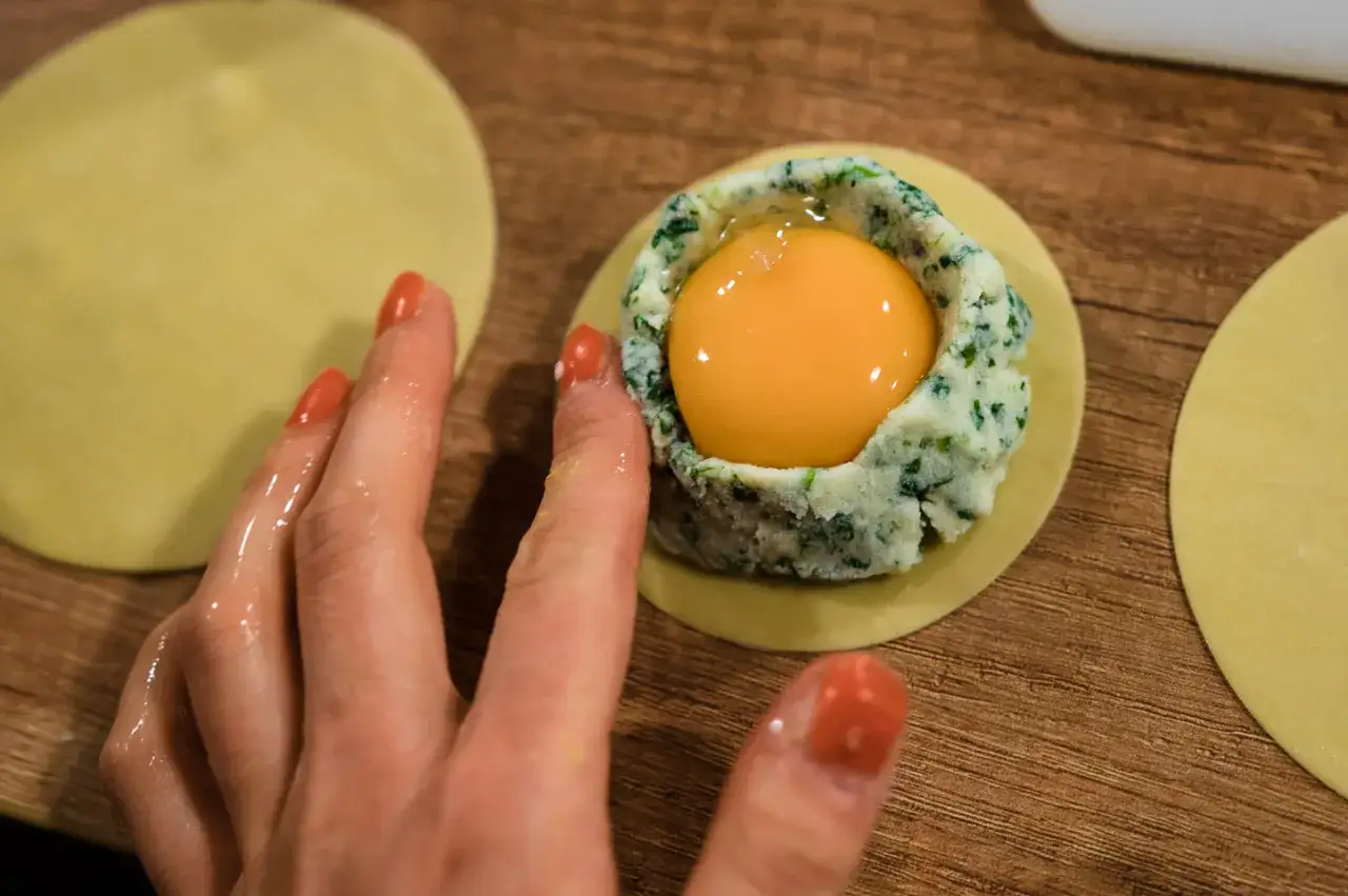 Ręka tworzy ravioli z płynnym żółtkiem, jak w MasterChef.
