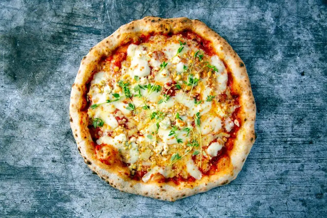 Pyszna pizza quattro formaggi z czterema rodzajami sera i świeżym tymiankiem, na chrupiącym cieście.
