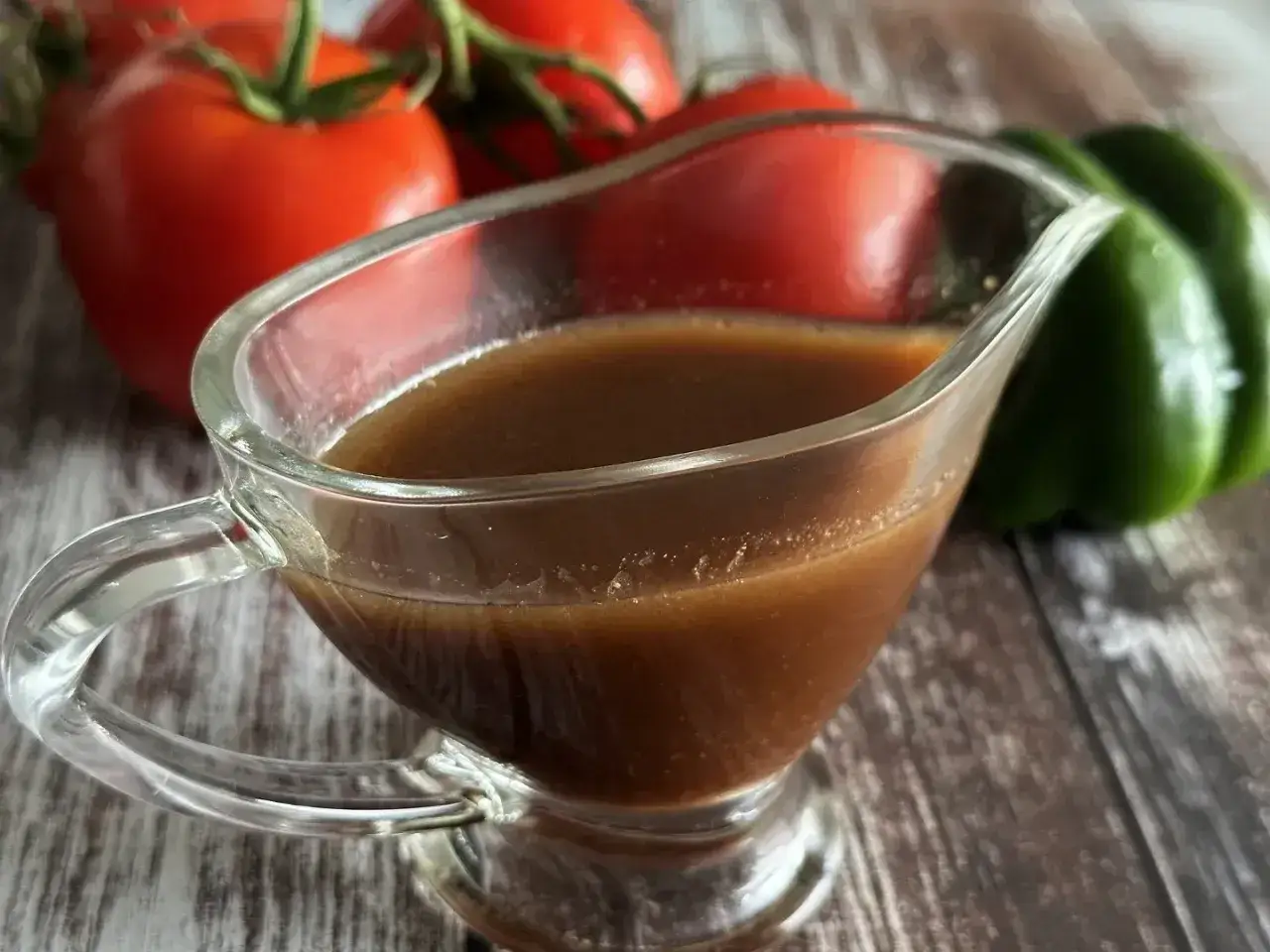Sos balsamiczny w sosjerce, obok pomidorów i papryki. Idealny do sałatek i mięs.