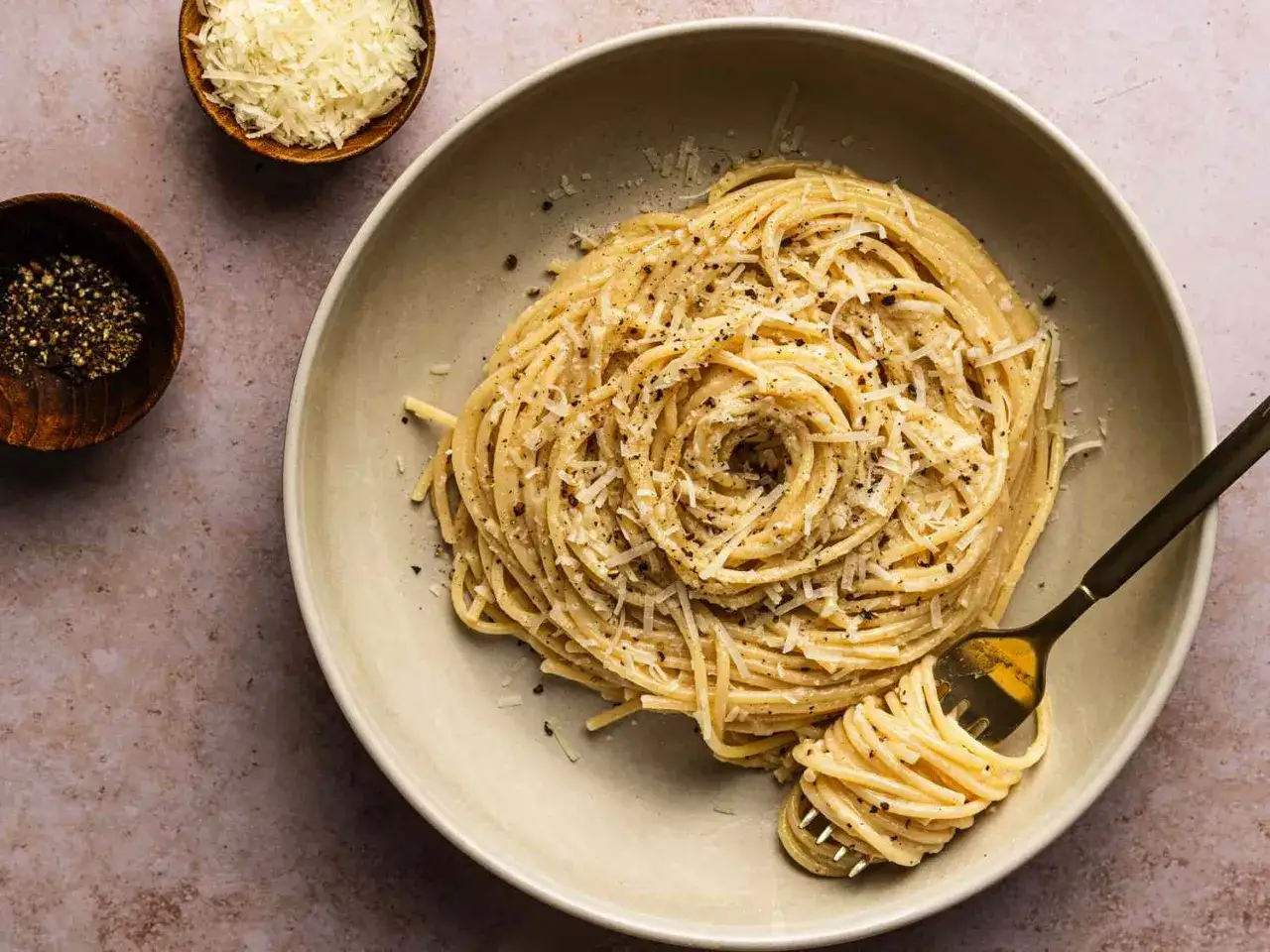Pyszne cacio e pepe, czyli spaghetti z serem i pieprzem, posypane dodatkowym parmezanem.